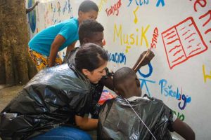 Tatiana Rodriguez helps Dominican children paint an educational mural in 2015.