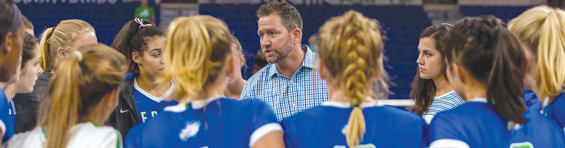 Photo of FGCU volleyball coach with team