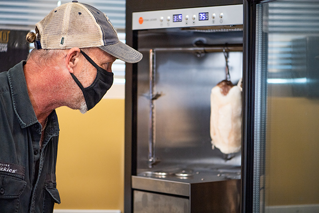 Photo shows instructor looking into a refrigerator.