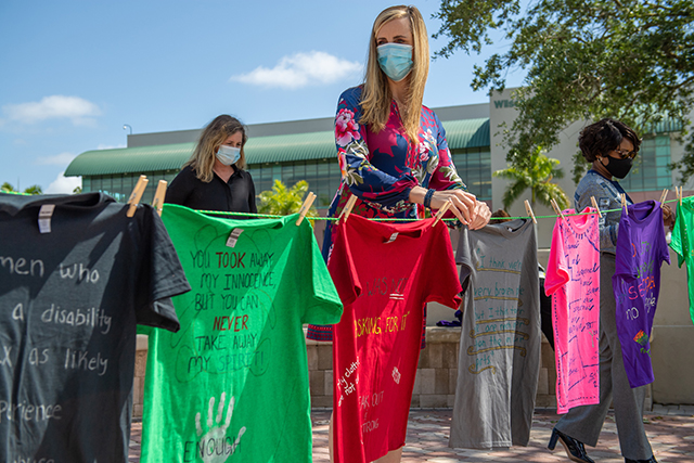 Photo shows FGCU faculty hanging T-shirt