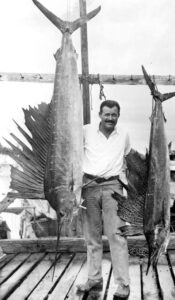 Portrait of author Ernest Hemingway posing with sailfish: Key West, Florida