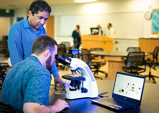 Photo shows FGCU professor and student in lab