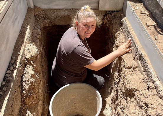 photo shows grad student exhuming a grave