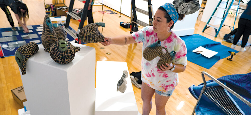 photo shows artist arranging her exhibit