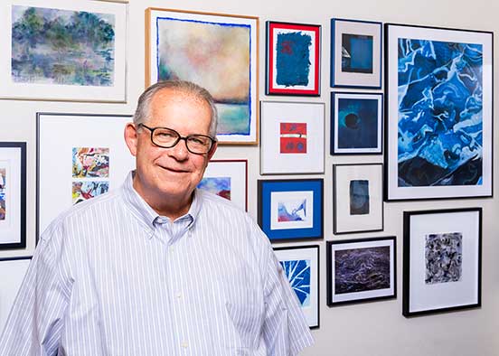 Robert Feir stands in front of some of his art collection