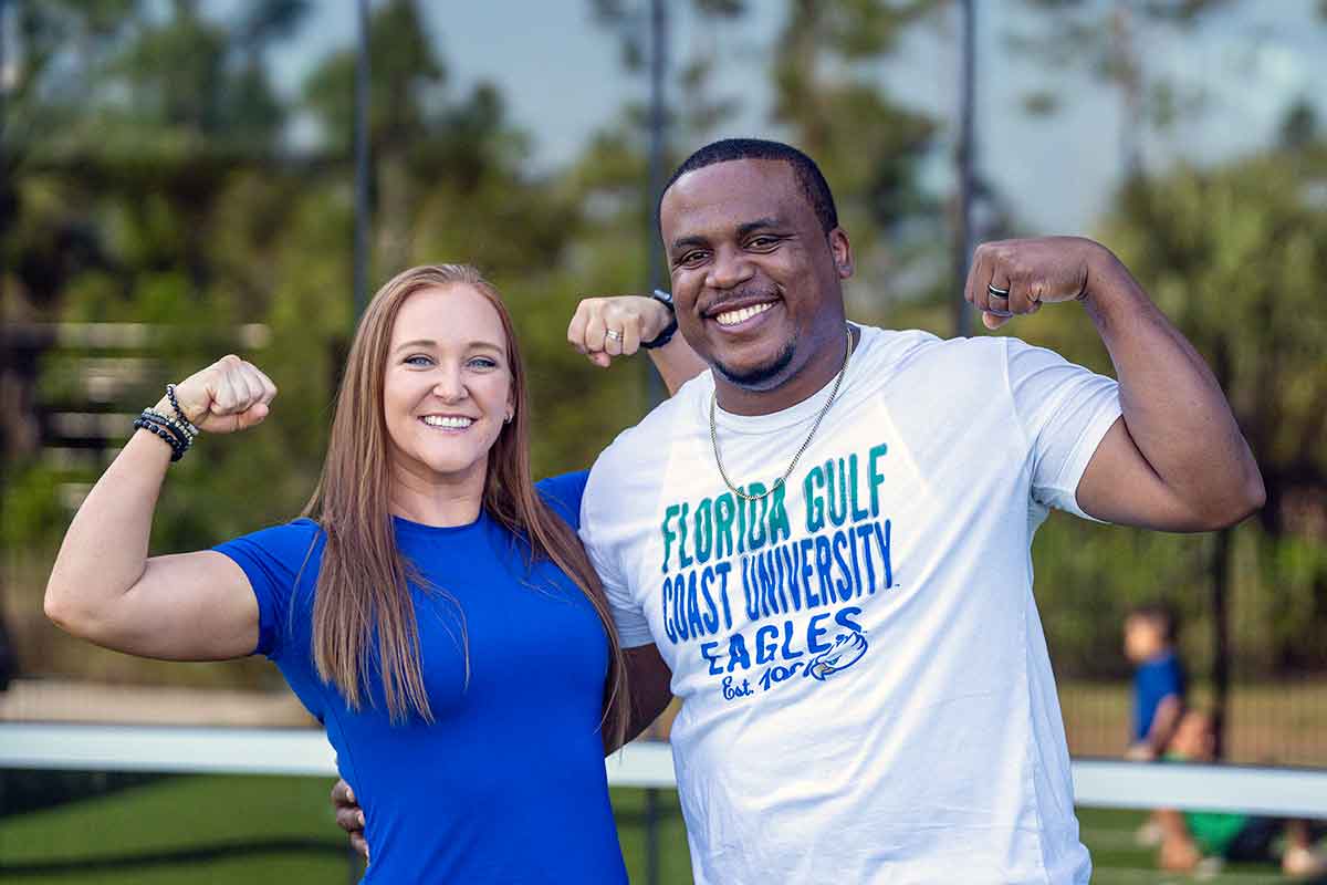 A woman in a blue shirt and a man in a white t-shirt that reads "Florida Gulf Coast University Eagles"