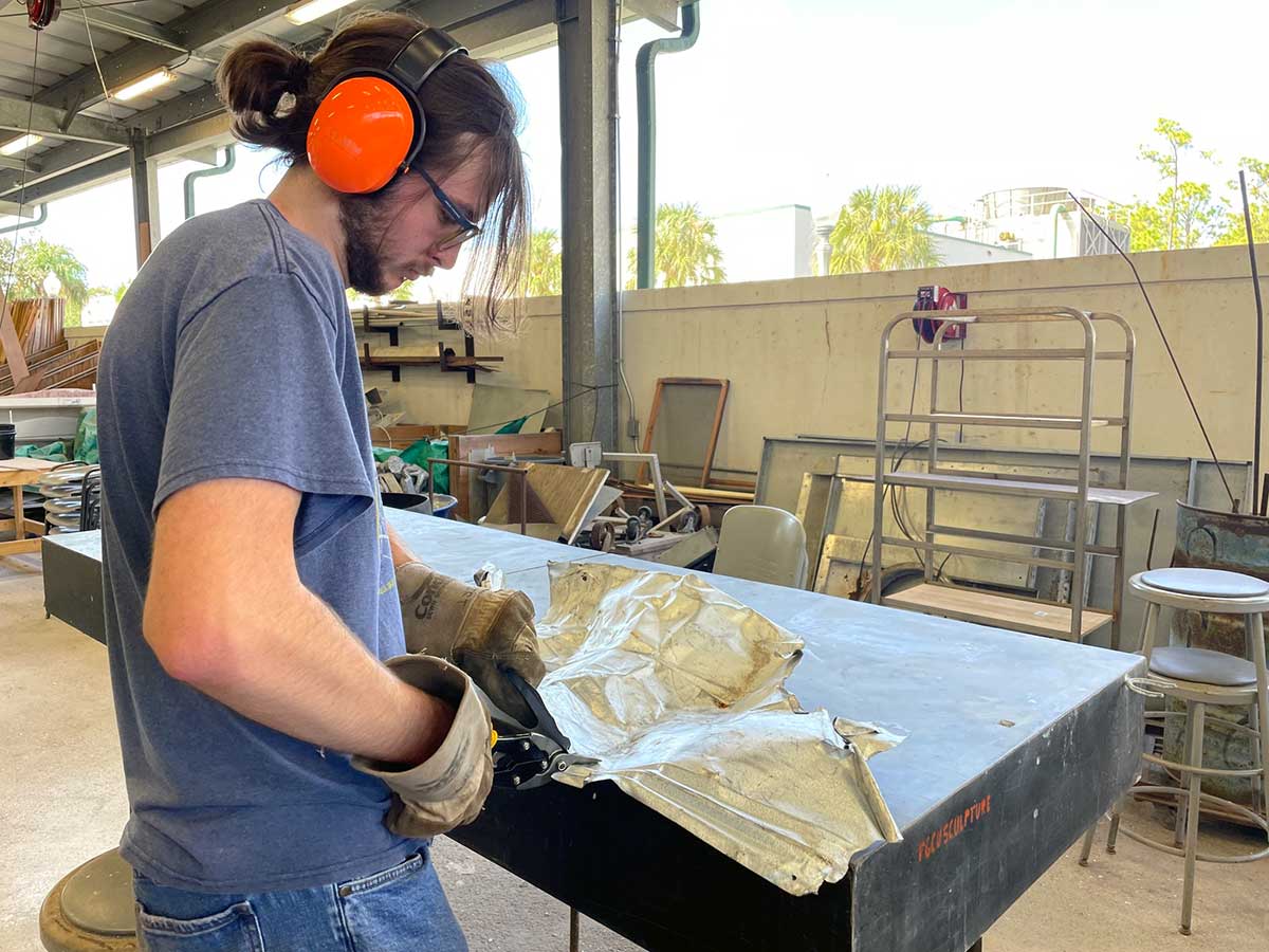 Nathaniel Bonds cutting scrap metal for sculpture