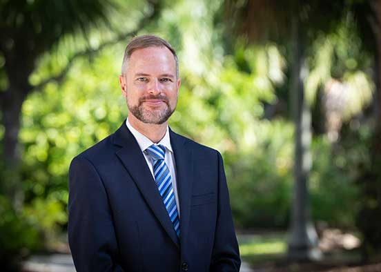 Tyler Fisher, dean of FGCU's Honors College poses on campus