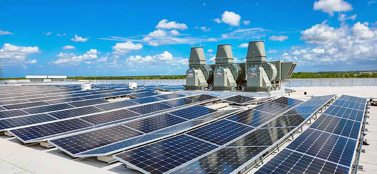 A panoramic view of a rooftop, covered in solar panels and HVAC equipment.