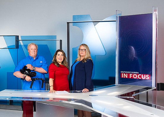 News team standing on set in TV studio