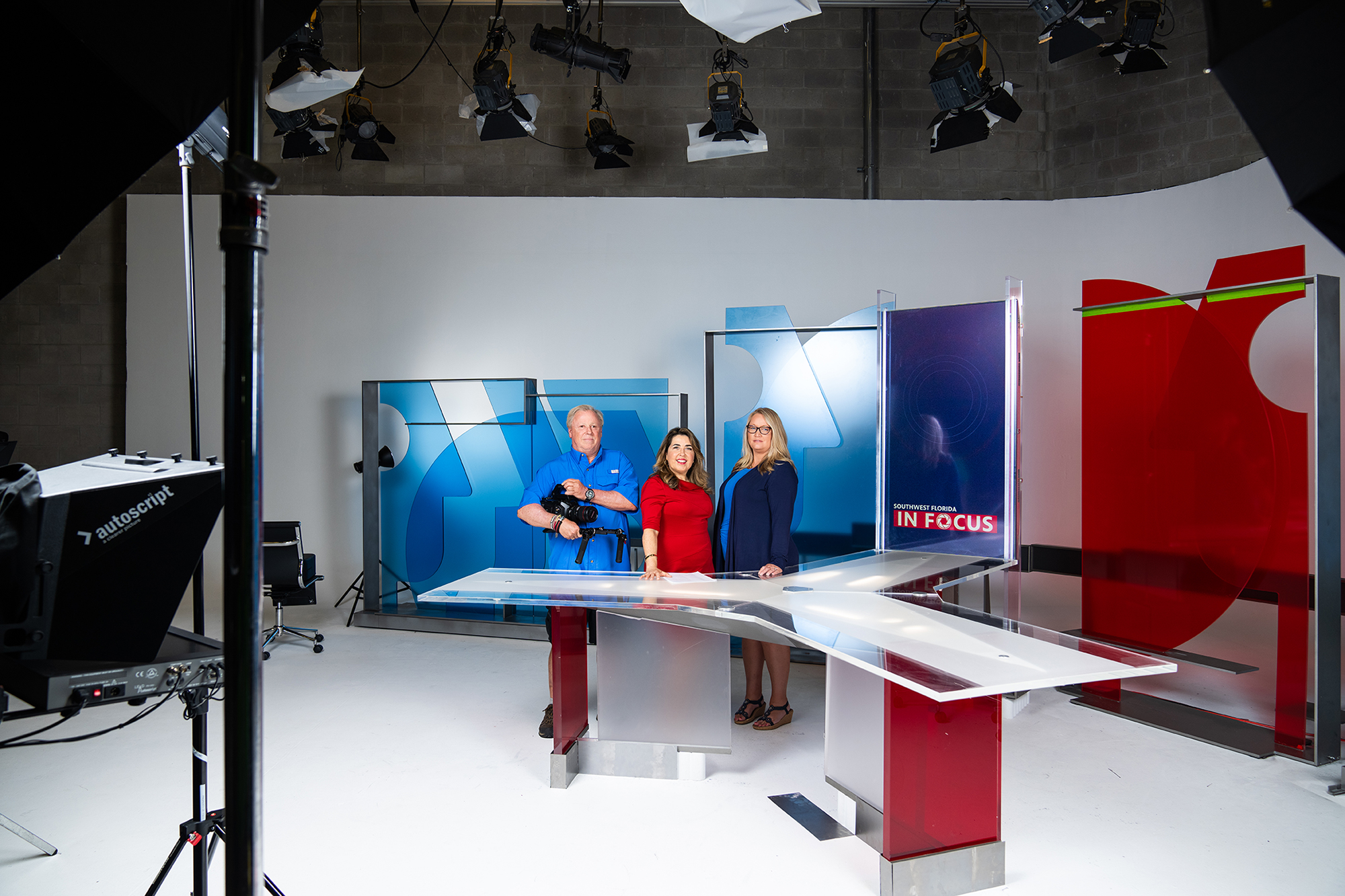 News team standing on set in TV studio