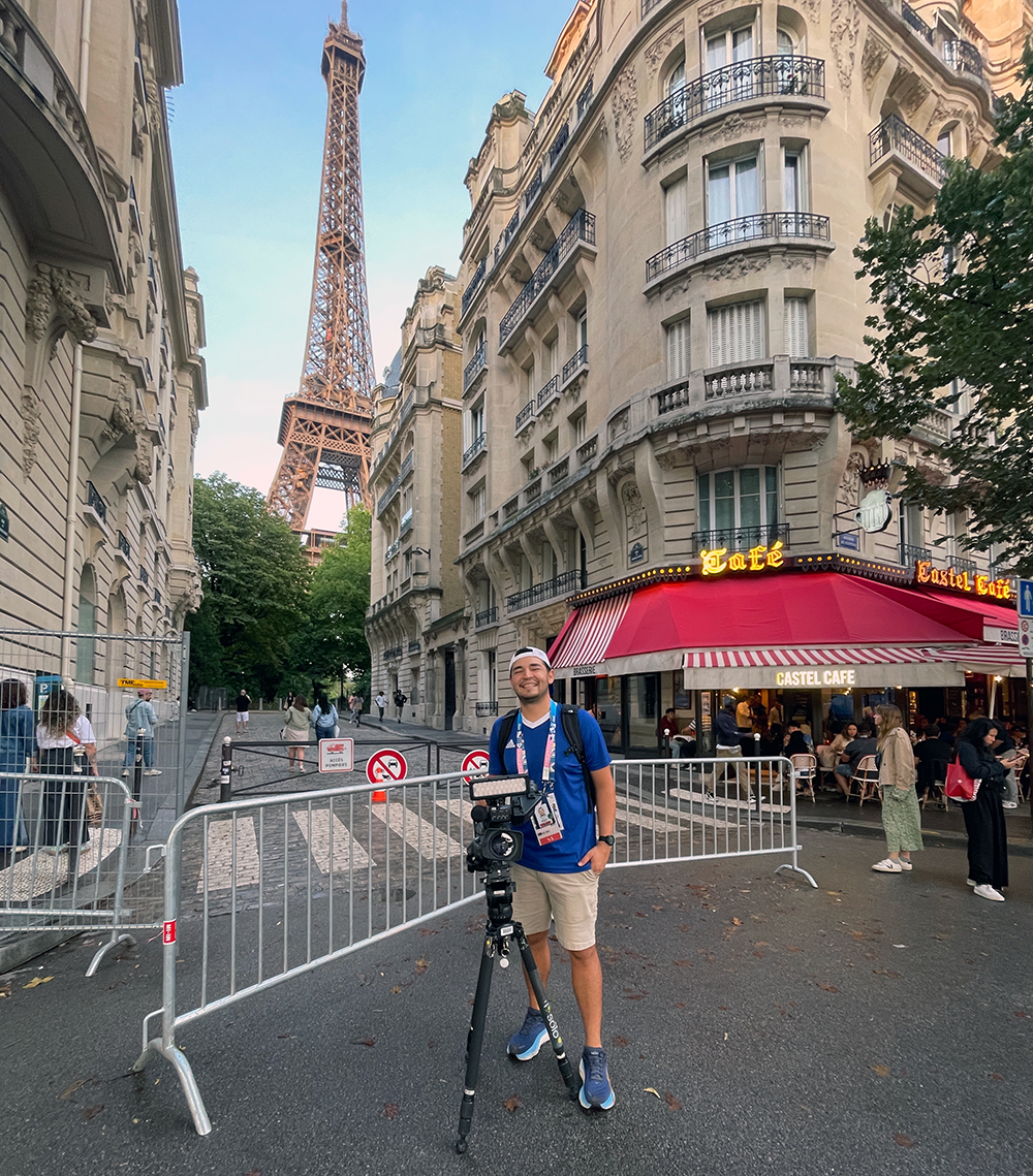 Man with video camera standing in Paris street by Eiffel Tower