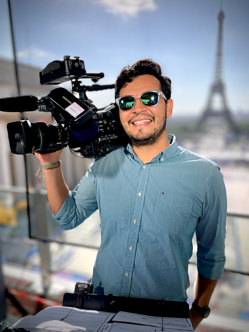 Man in sunglasses holding video camera.