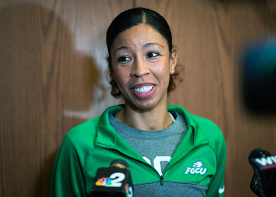 Woman in green track jacket with microphones