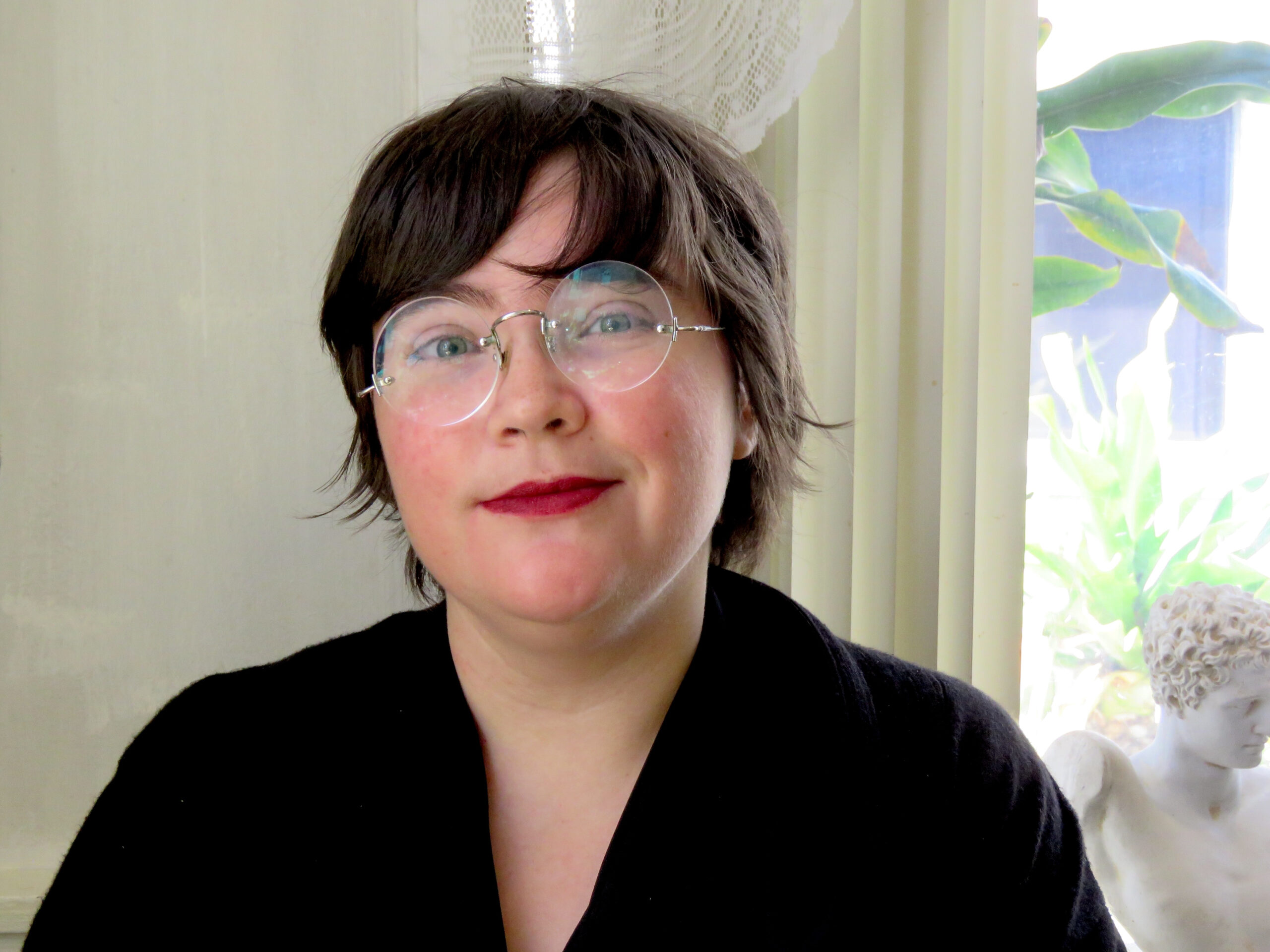 Brown-haired woman wearing glasses and black shirt