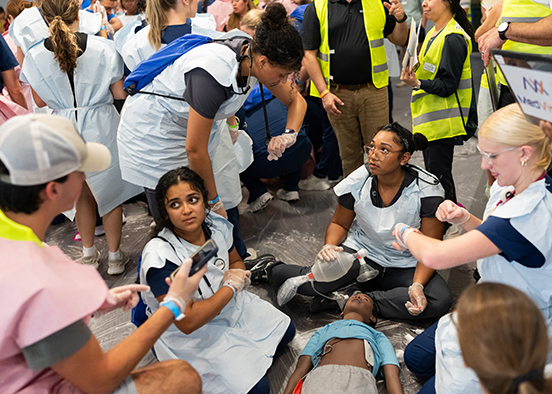 Students treat a fake patient during an emergency simulation