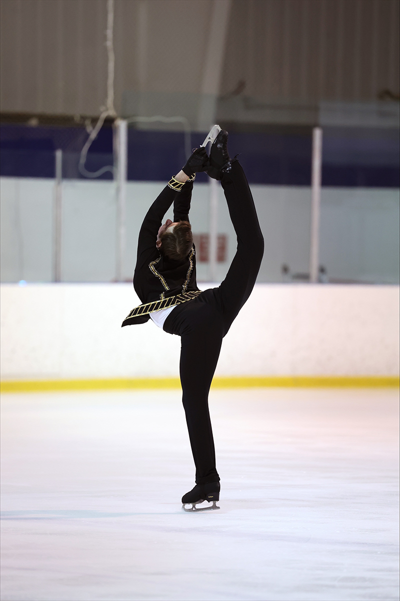 Man in black costume ice skating