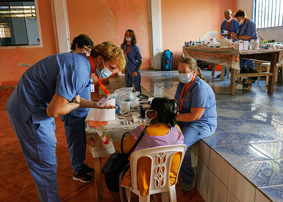 Student wearing scrubs providing medical supplies in Peru clinic