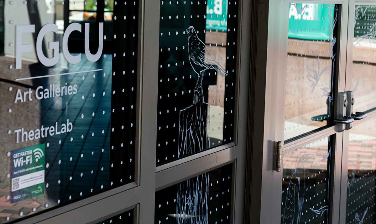 Windows covered in white dots in a grid with some designs of birds in a natural environment and the words FGCU Art Galleries and Theatre Lab