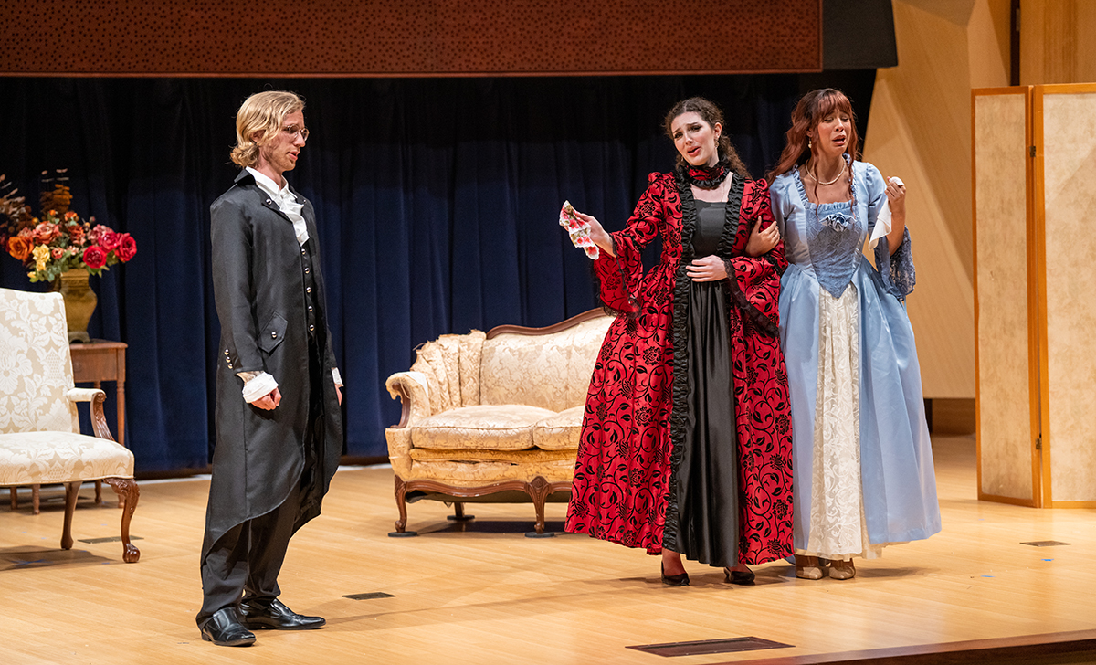 Three students in costumes performing an opera piece.