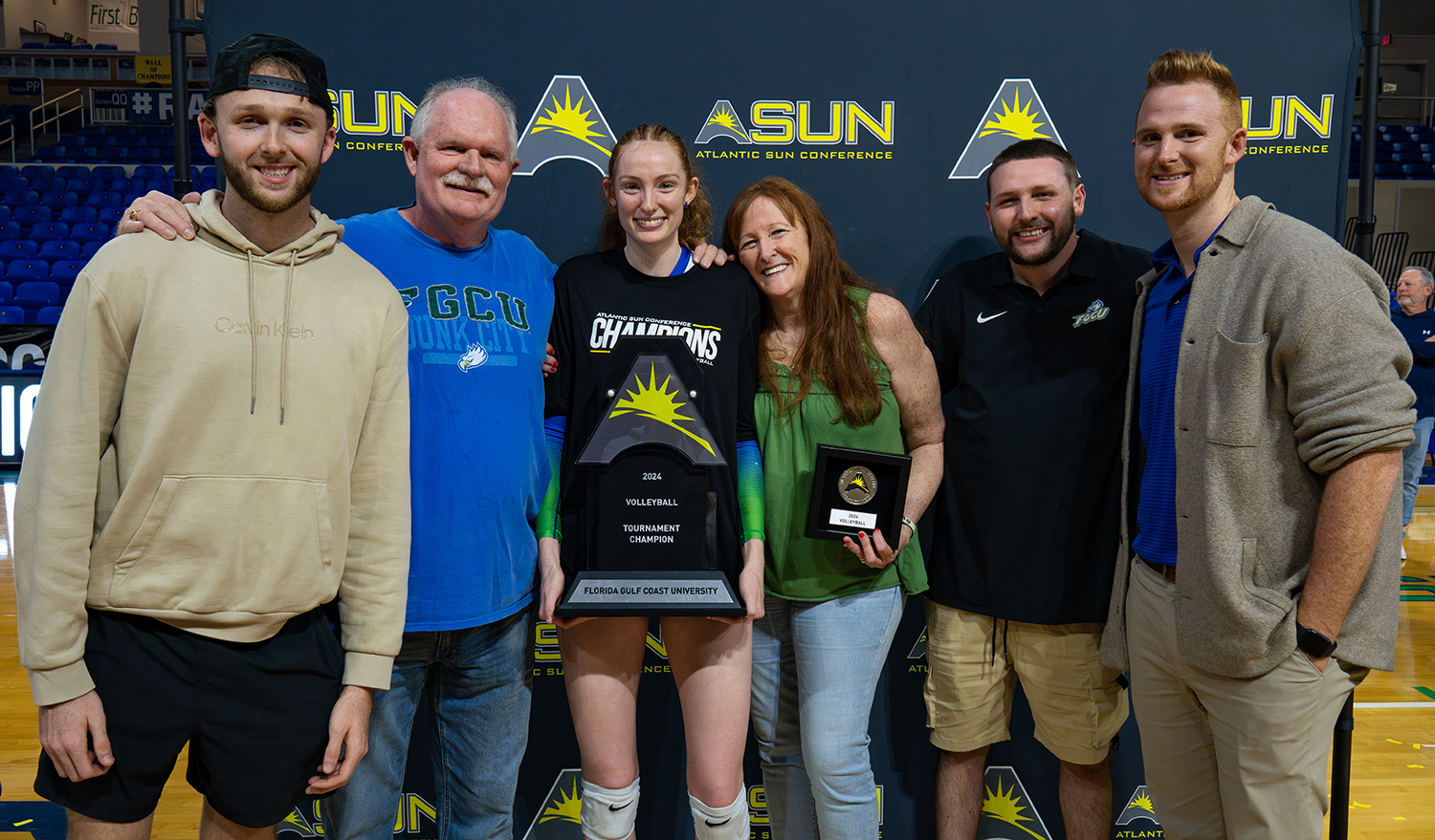 Six men and women posing with a trophy