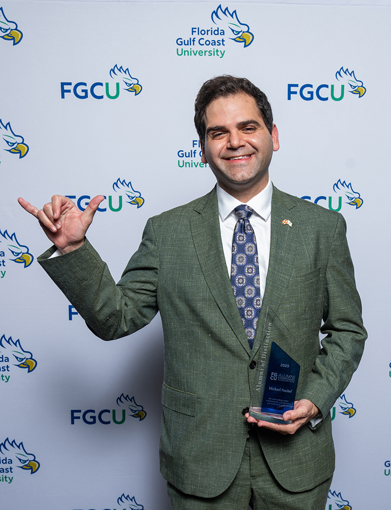 Man in suit making Wings Up hand gesture