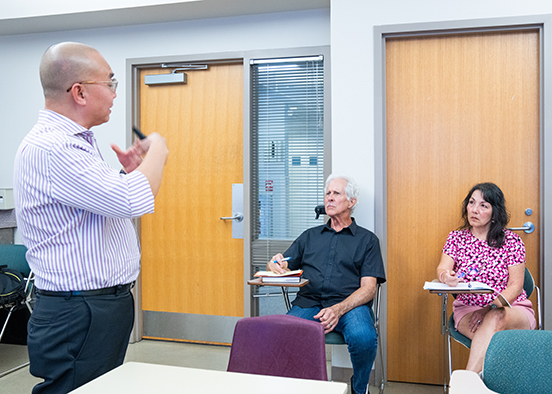 instructor talking to two students in classroom