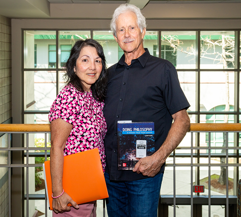 Woman and man standing in hallway holding textbooks