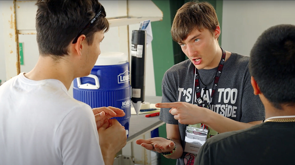 Three students in T-shirts talking