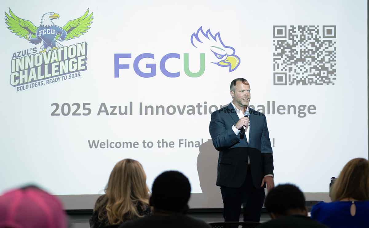 A man in a suit stands in front of a screen with the words 2025 Azul’s Innovation Challenge.