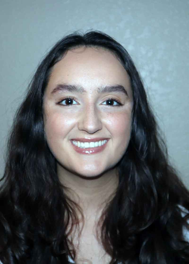 A headshot of a smiling young woman
