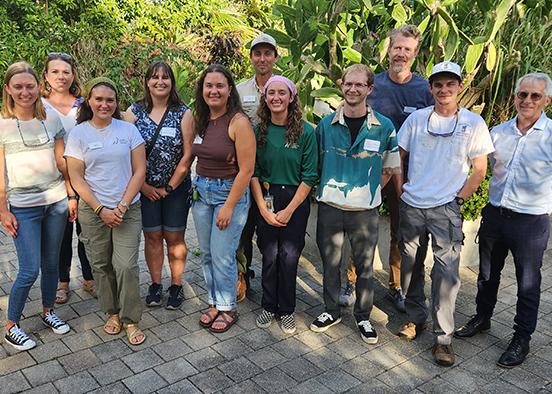 A panoramic photo of one dozen people outdoors