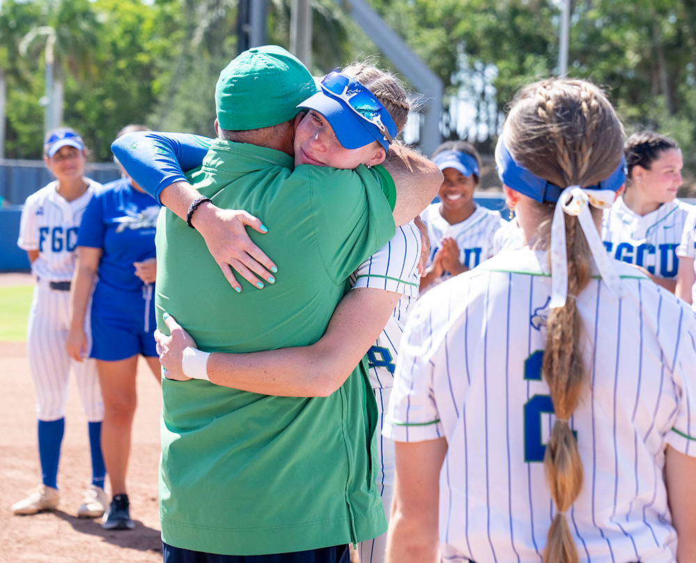 Softball player hugging her coach