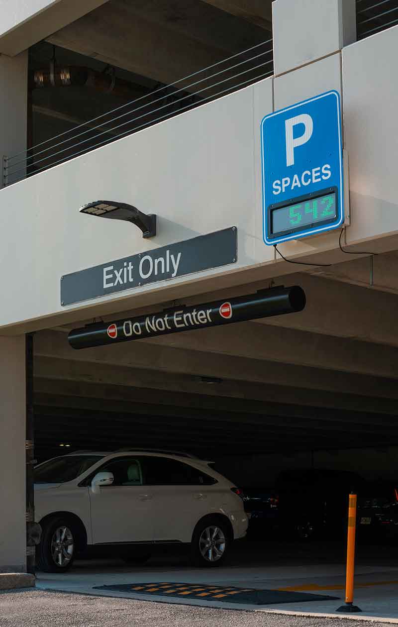 A parking garage entrance-exit with Exit Only and Do Not Enter signs, and a blue sign reading P spaces and the number 542, indicating there are 542 open parking spaces