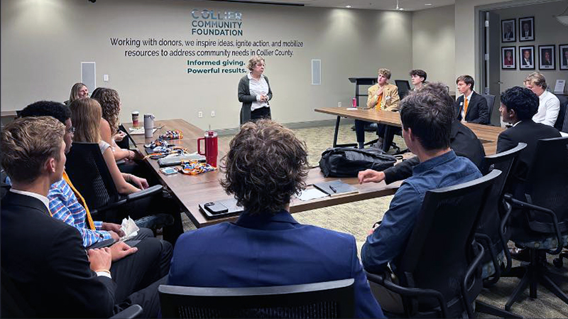 Meeting at Collier Community Foundation with a speaker addressing a group seated around a conference table.