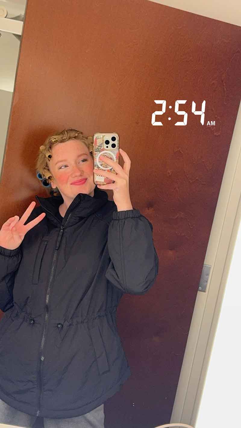 A selfie in a mirror of a woman in hair curlers making a peace sign. Text added to the photo reads 2:54 am