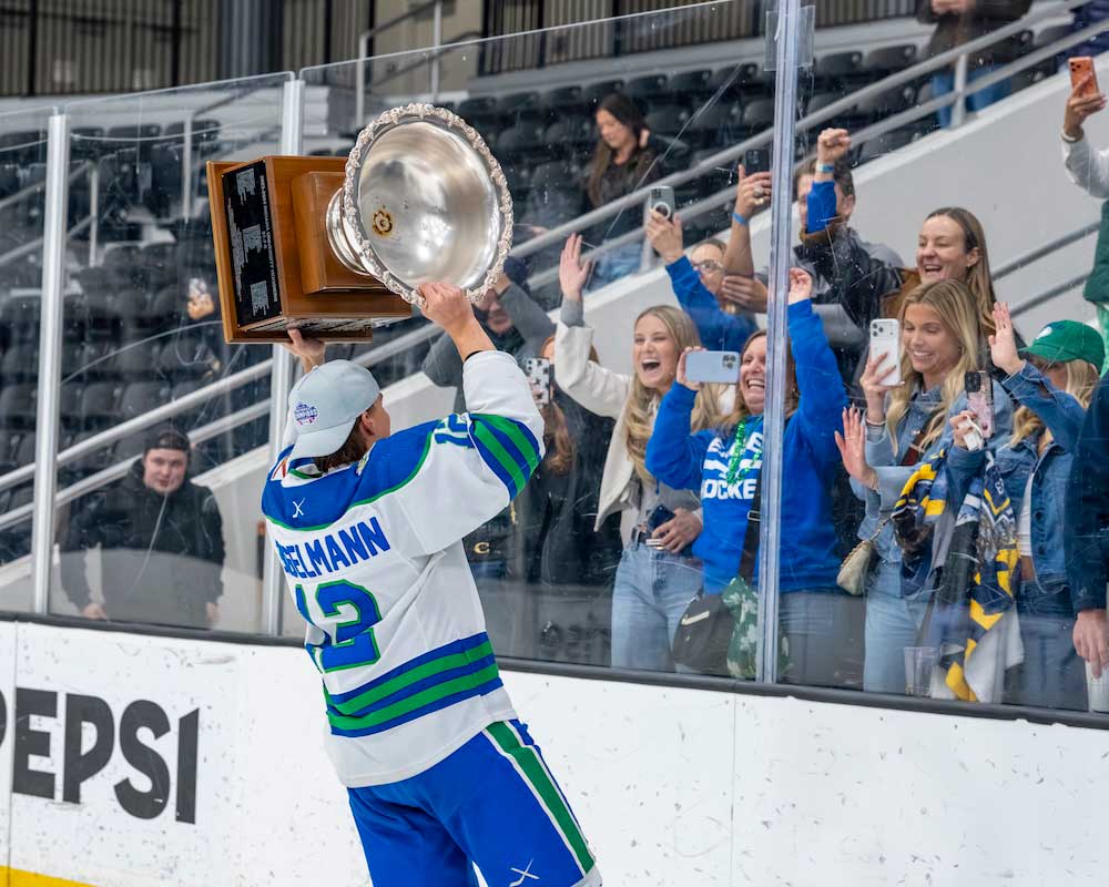 FGCU hockey player lifts ACHA Division II trophy toward cheering fans