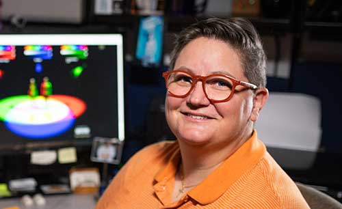 Person in orange shirt sitting at desk