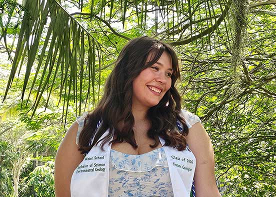 Woman standing under trees wearing The Water School stole.