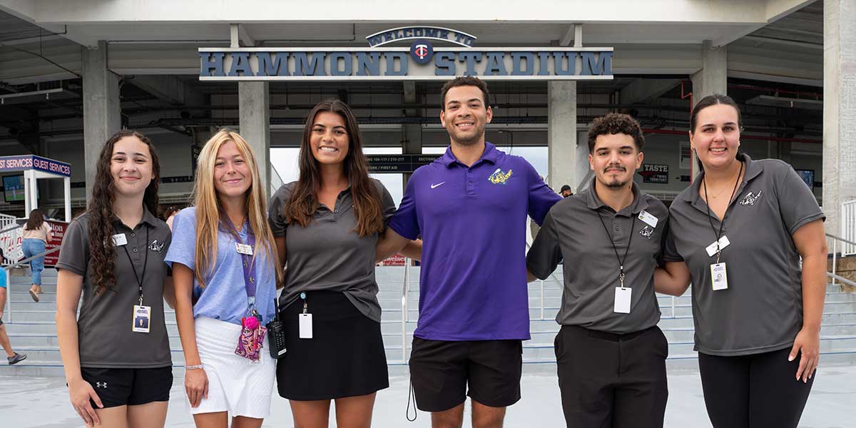 FGCU students and Mighty Mussels staff pose outside Hammond Stadium entrance