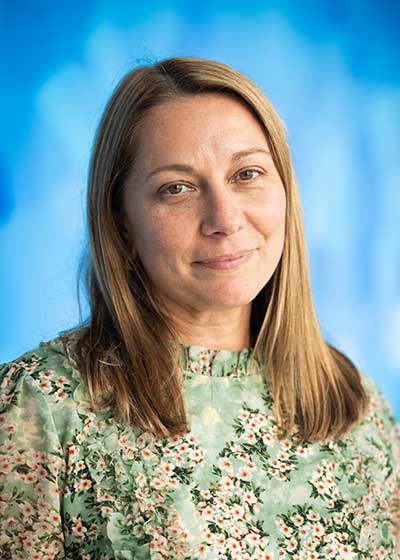 Woman in multicolored top against blue background