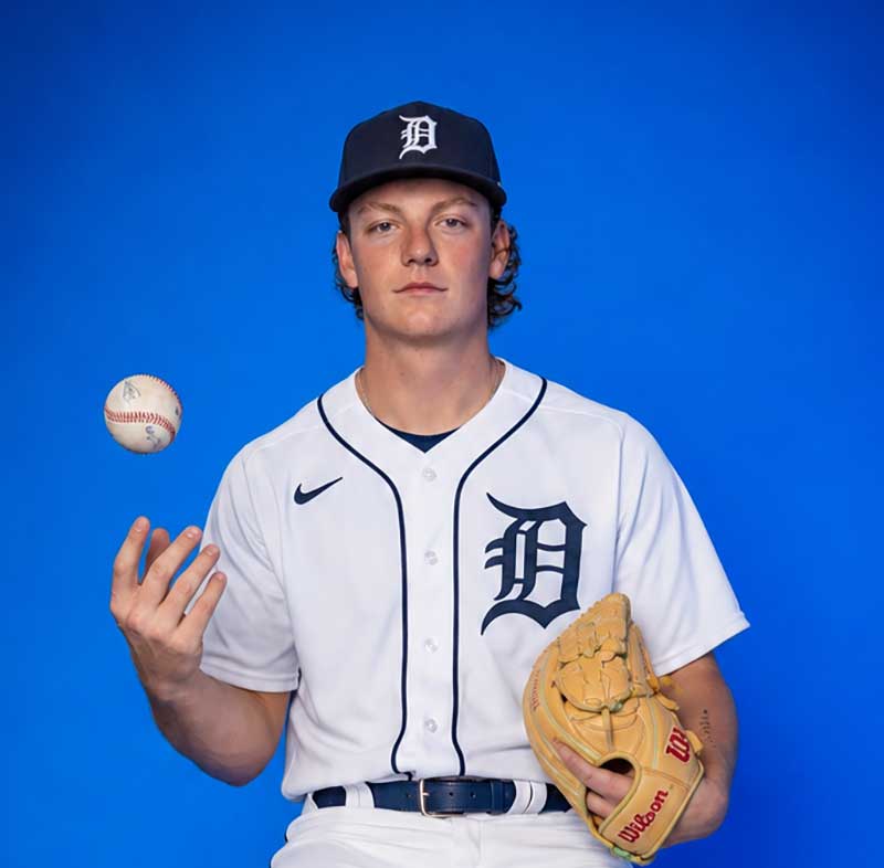 Baseball player in Detroit Tigers uniform tossing a ball