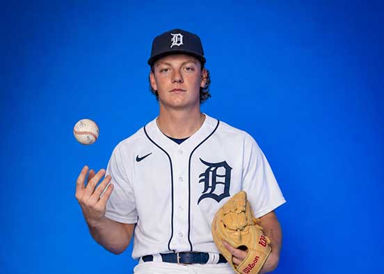 Baseball player in Detroit Tigers uniform tossing a ball