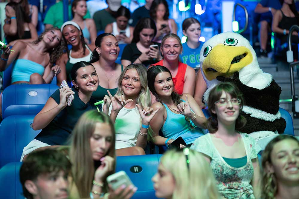 FGCU students pose with the Eagles mascot at campus welcome event.