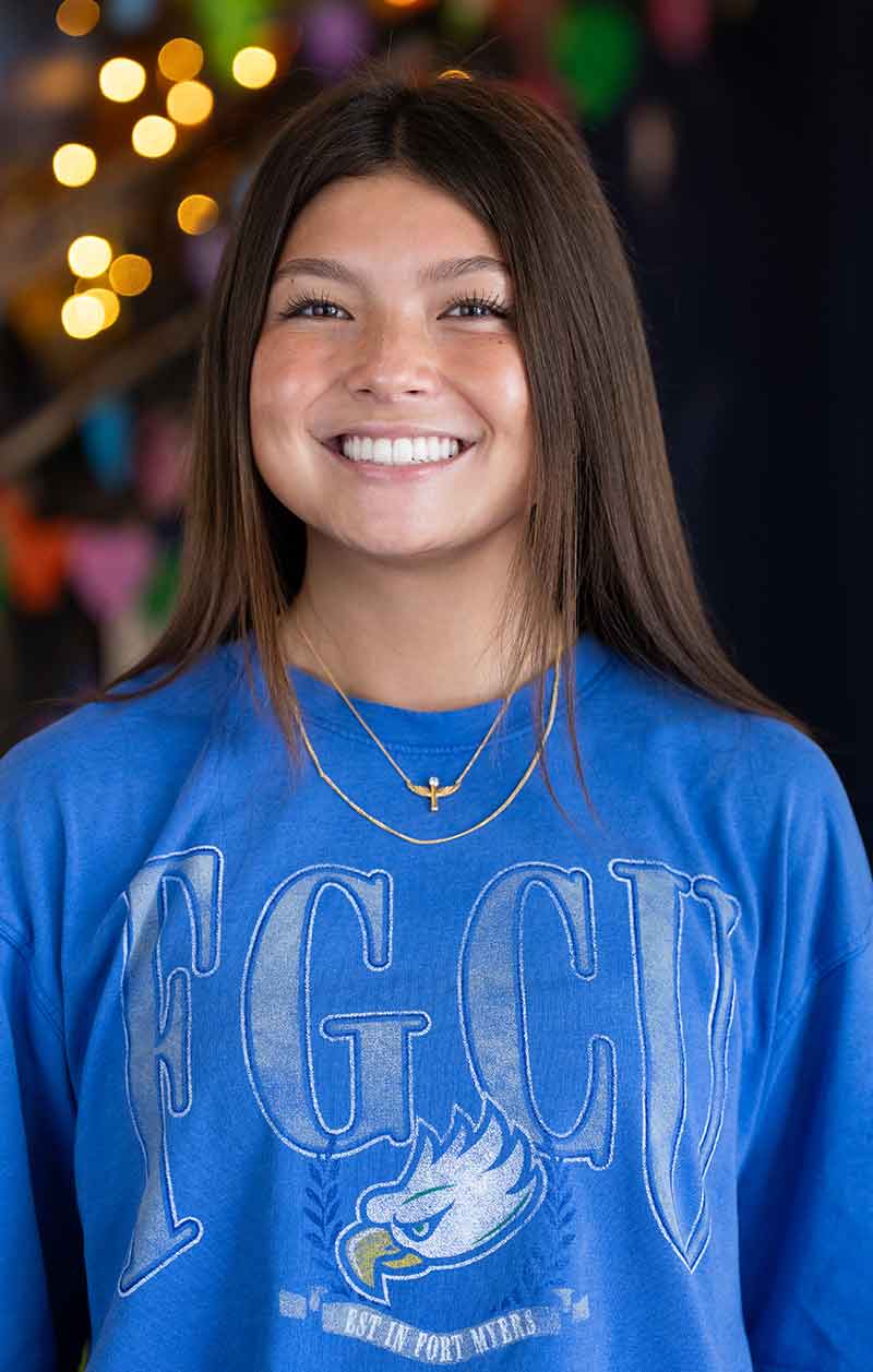A young woman in a blue FGCU t-shirt