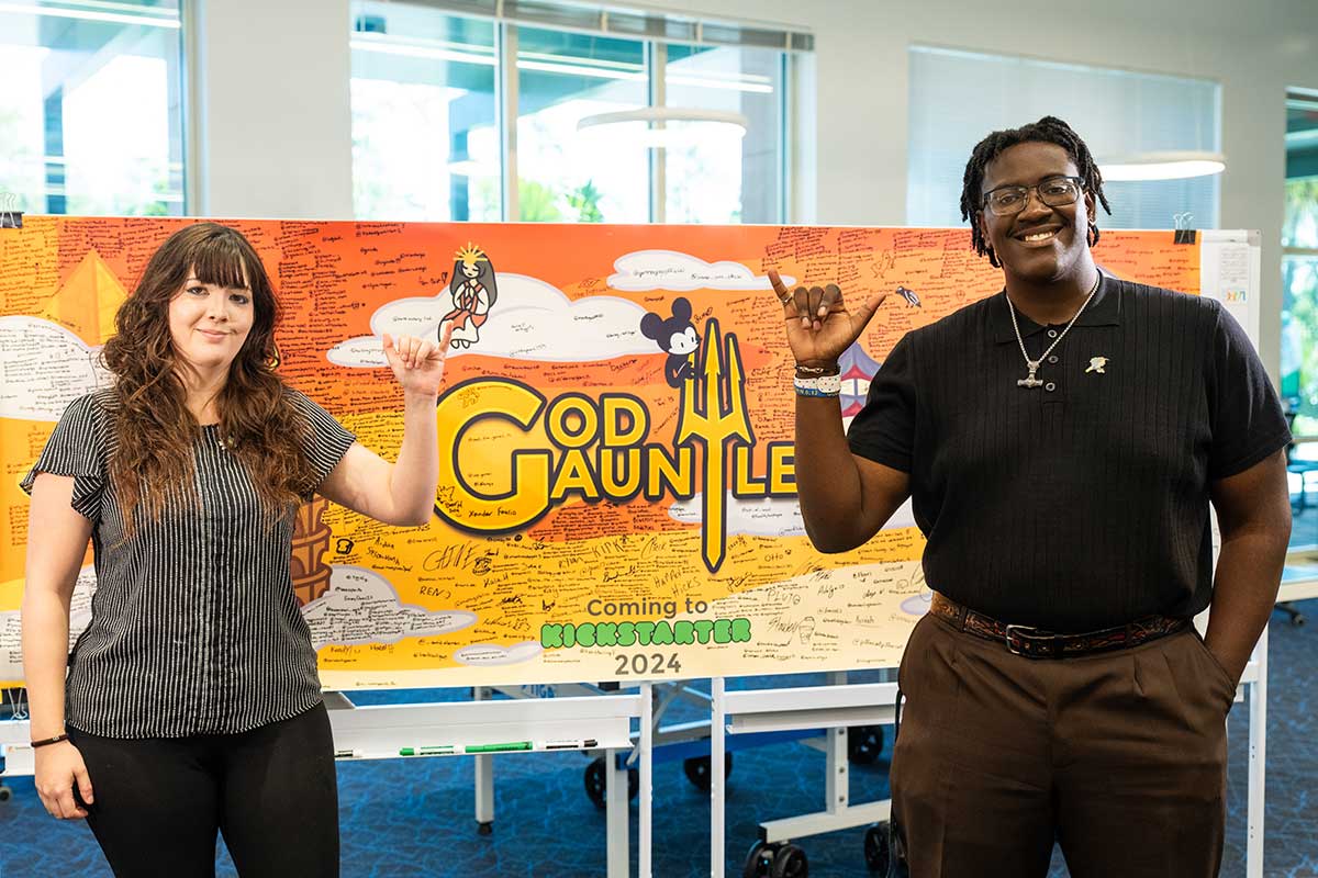 FGCU student entrepreneurs with God Gauntlet display promoting startup success.