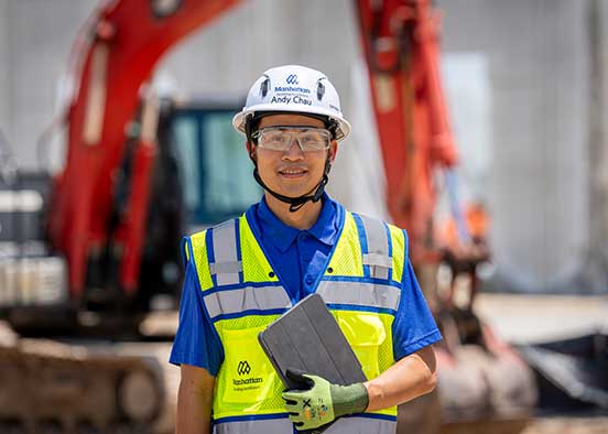 Construction engineer with tablet at active jobsite excavation area