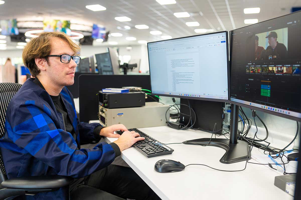 Student edits digital media content on dual monitors in production lab