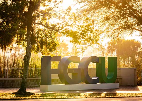 Ginat FGCU logo on campus at sunrise