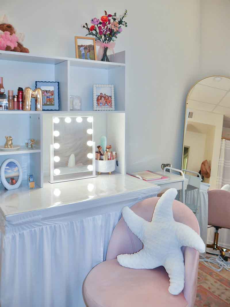 A vanity and workspace combination, illuminated makeup mirror, full-length mirror and pink desk chair with starfish-shaped pillow